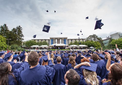 Students at Commencement tossing their graduation caps into the air