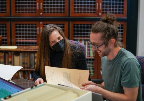 A professor working in the library with a student on a research project
